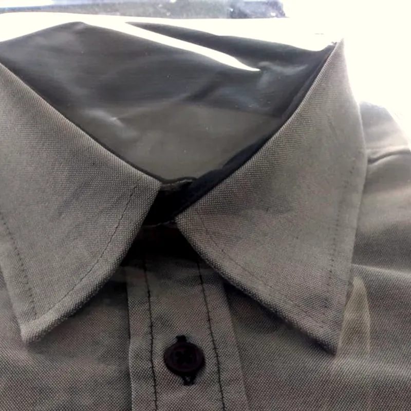 Colarinho de camisa cinzenta, com o botão do pescoço em contraste