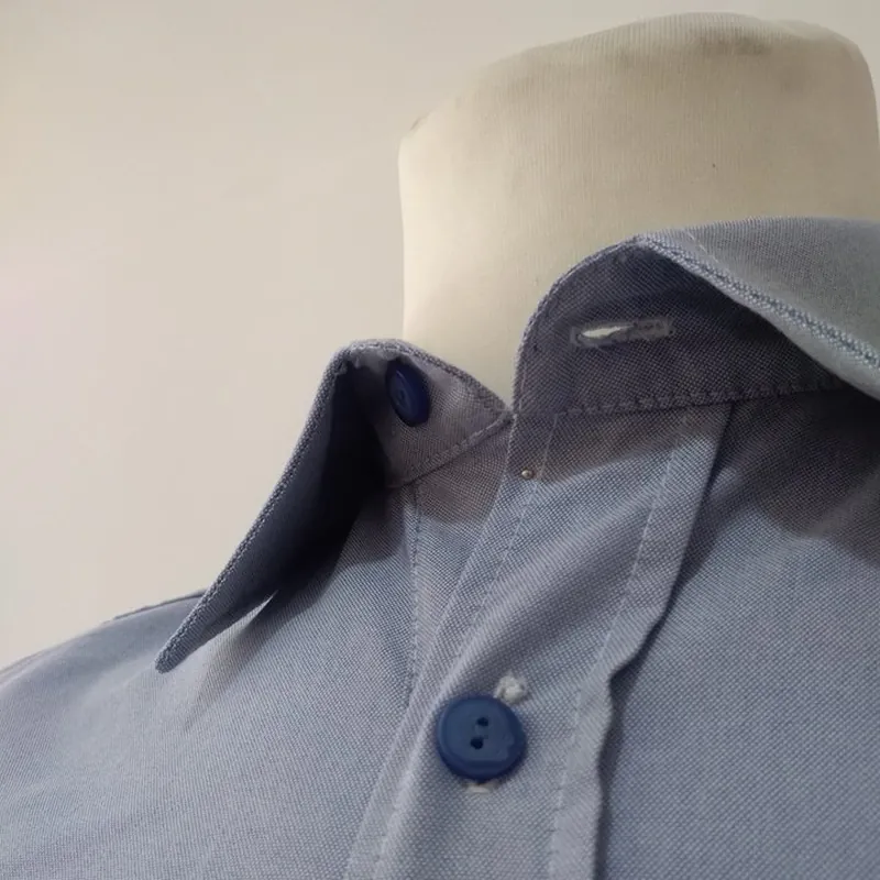Colarinho de camisa azul-clara com gola interior azul-escura e botão a condizer